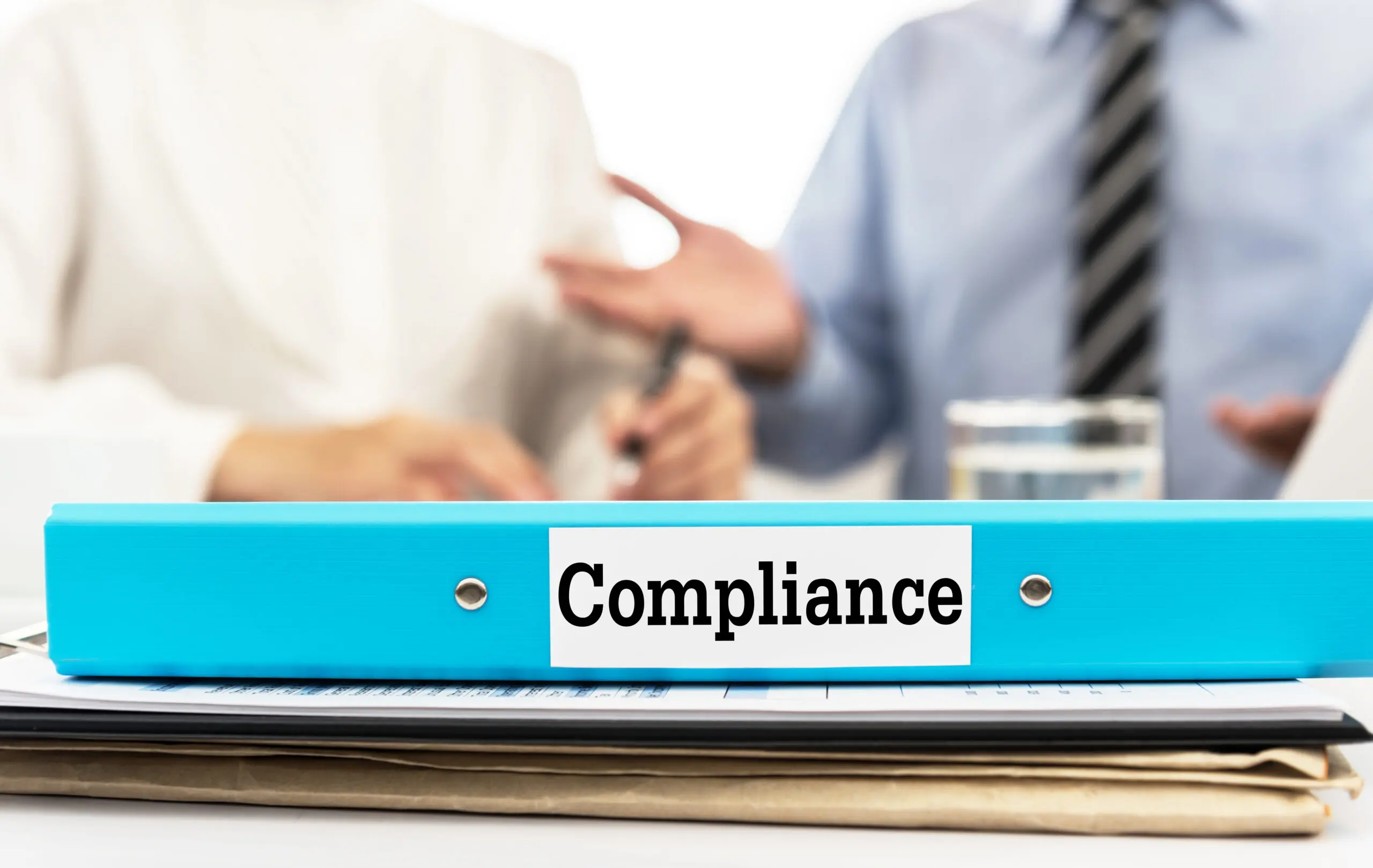 Compliance,Document,Folder,On,Desk,In,Meeting,Room,With,Business